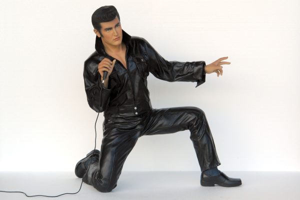 ROCK & ROLL SINGER KNEELING WITH MICROPHONE